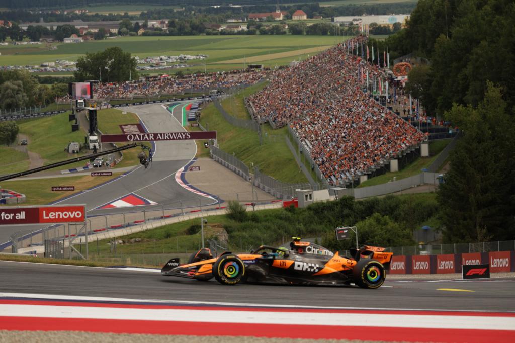 McLaren's Lando Norris during Austrian Grand Prix second practice with a grandstand and Spielberg hills in the background