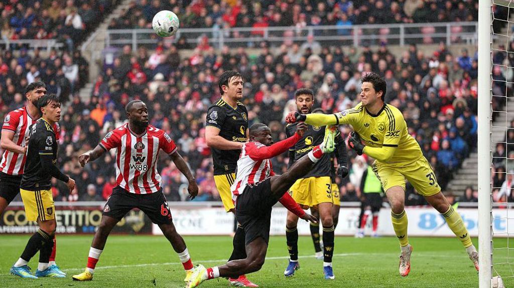 Senne Lammens of Manchester United clears the ball under pressure from Brian Brobbey of Sunderland