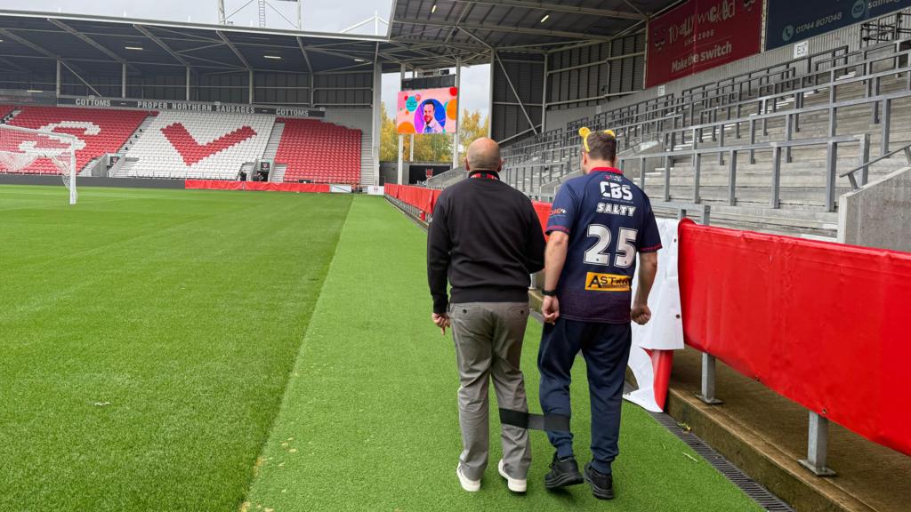 People walking around a football ground