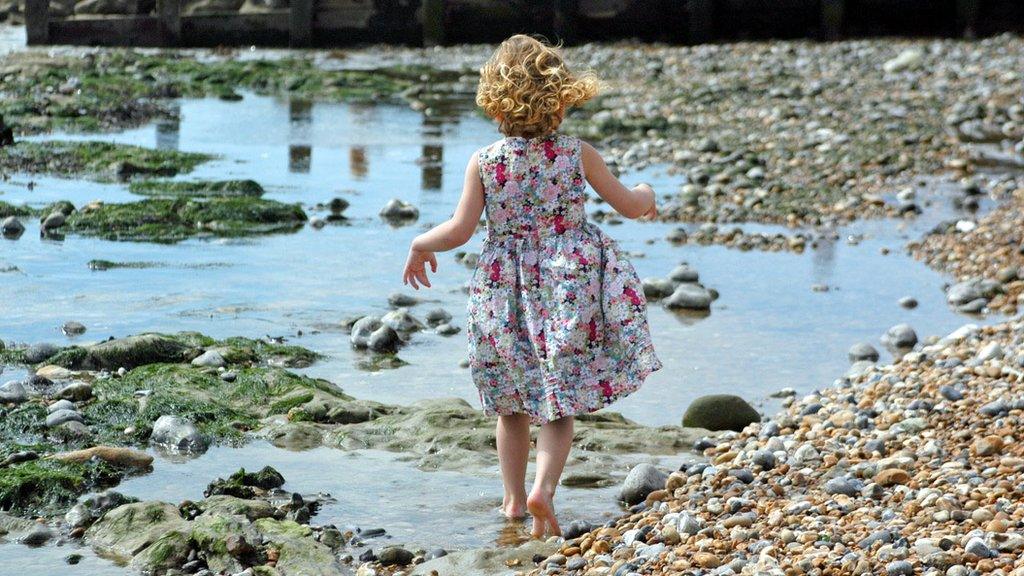 Little girl walking on a beach