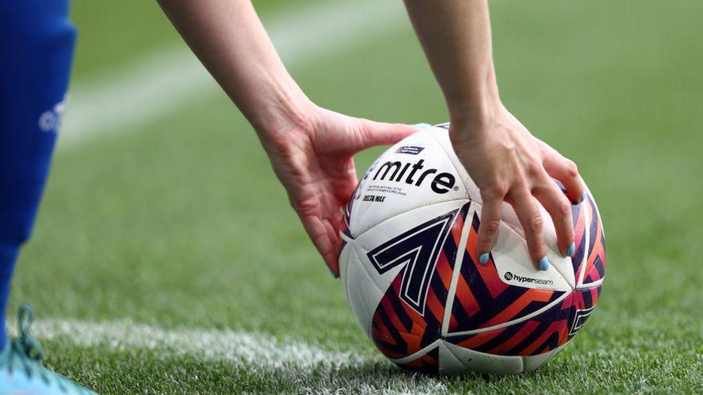 A player puts a ball on the pitch