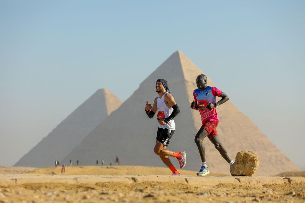 Two runners run side-by-side during the Marakez Pyramids Half Marathon in Giza, the largest city in Egypt - Saturday 14 December 2024