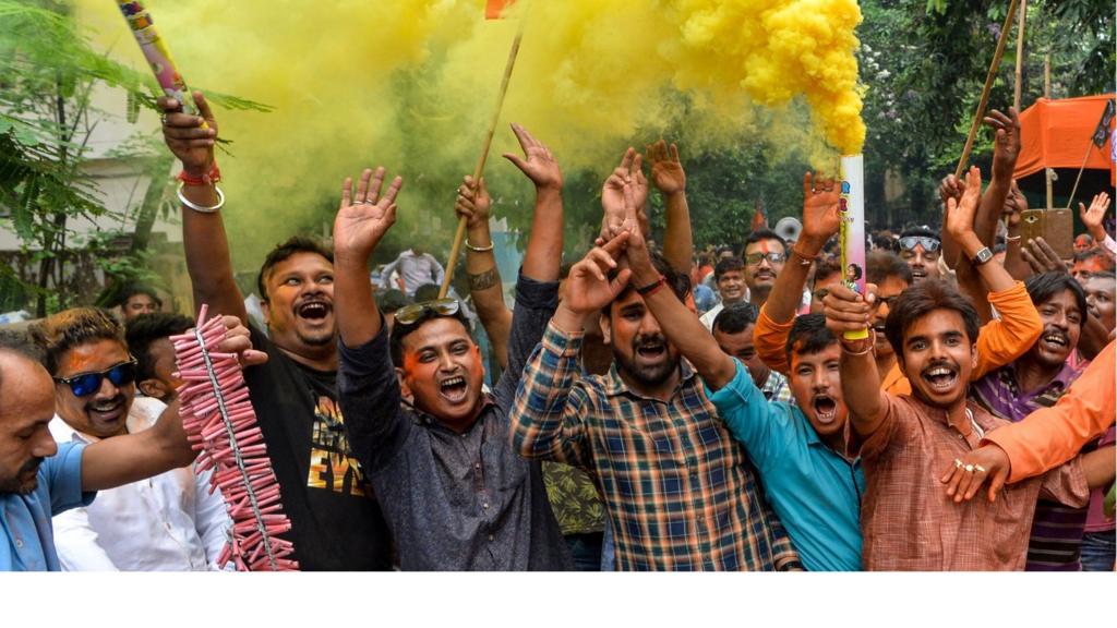 Indian supporters of Bharatiya Janata Party (BJP) hold colour smoke crackers as htey celebrate on the vote results day for India"s general election in Siliguri on May 23, 2019. -