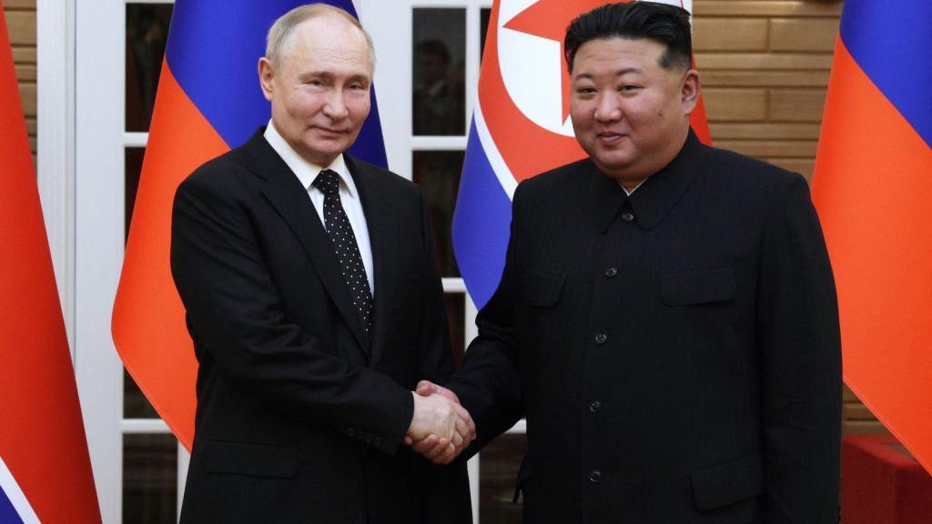 Kim Jong Un (right) and Vladimir Putin shake hands after a welcoming ceremony at Kim Il Sung Square in Pyongyang on June 19, 2024