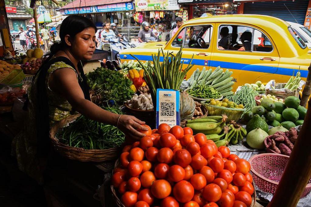 A  vegetable vendor waits for customers, displaying a barcode for Paytm, an Indian cellphone-based digital payment platform, at a market in Kolkata.