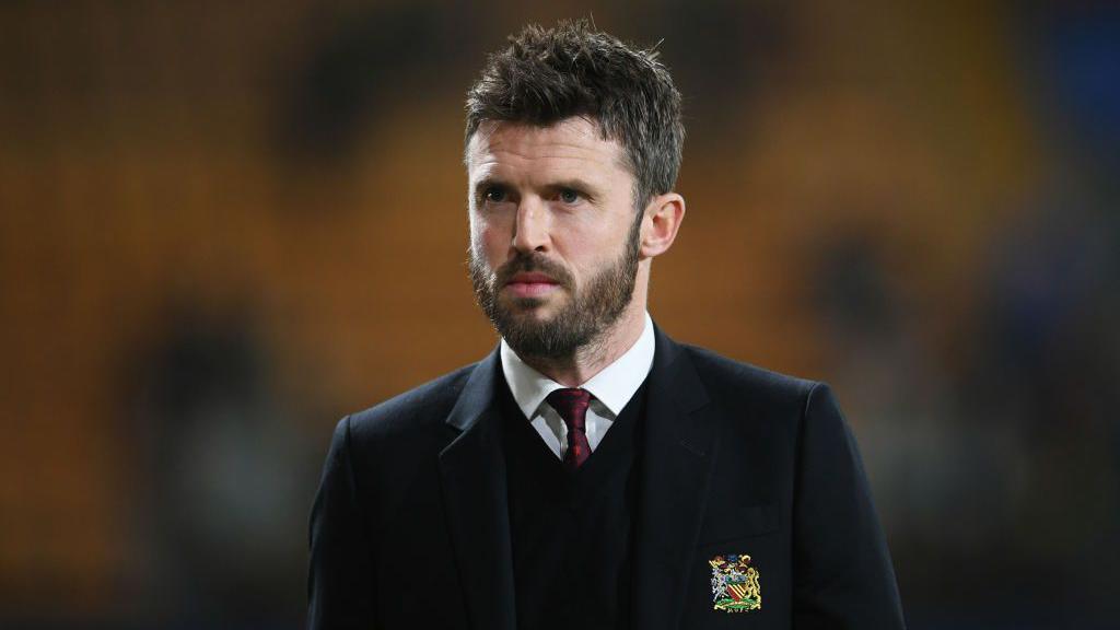 Michael Carrick wearing a suit and Manchester United blazer