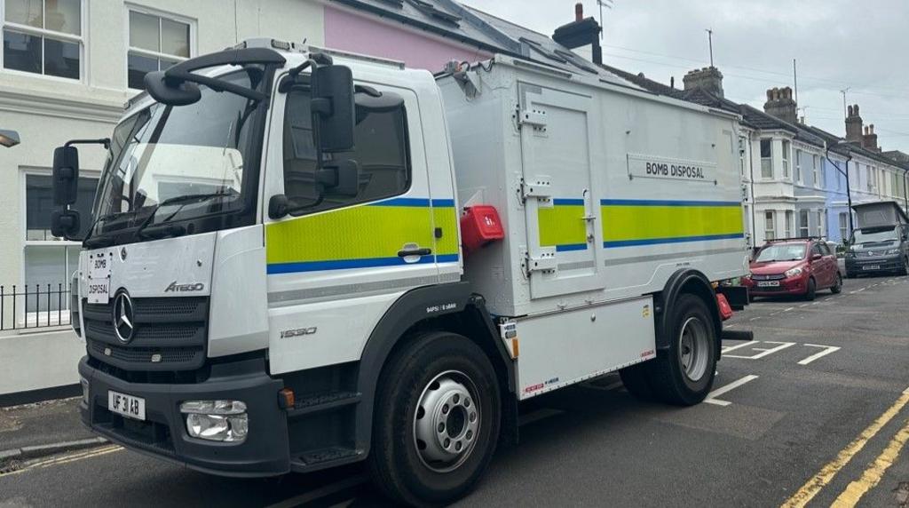 A bomb squad van on a street of terraced houses