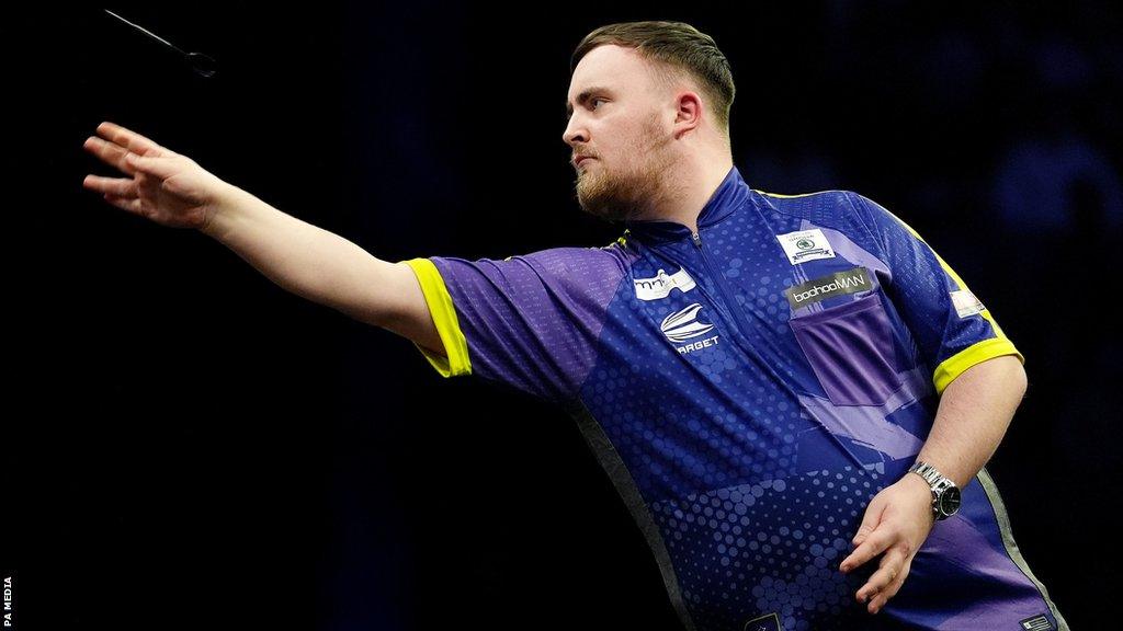 Luke Littler throws a dart during night 10 of Premier League Darts in Manchester