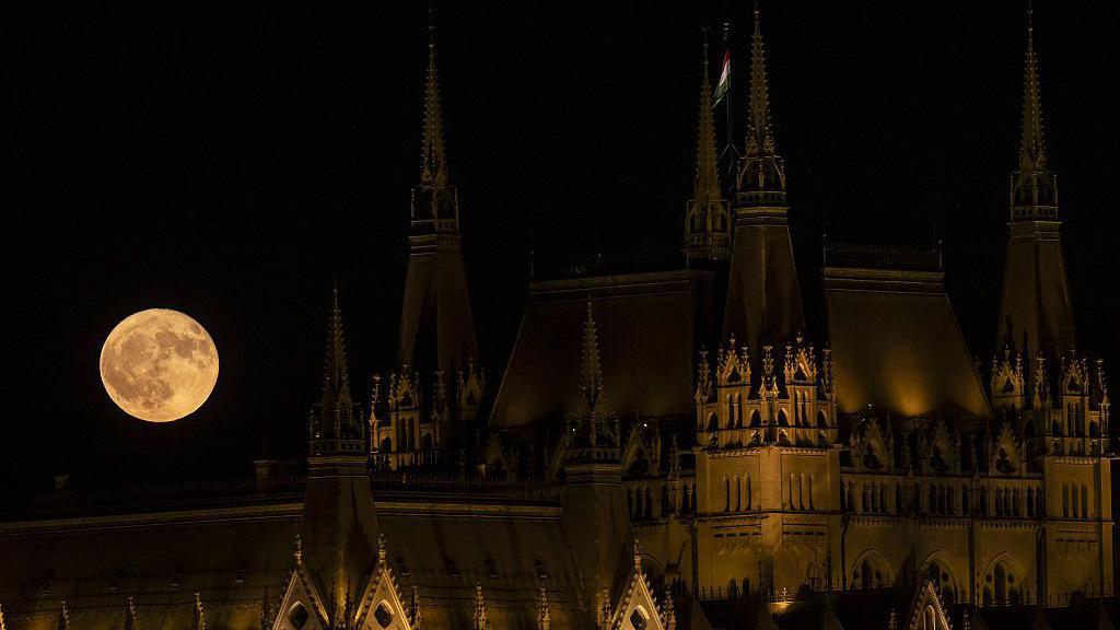Strawberry Moon rising over the Parliament in Budapest, Hungary.