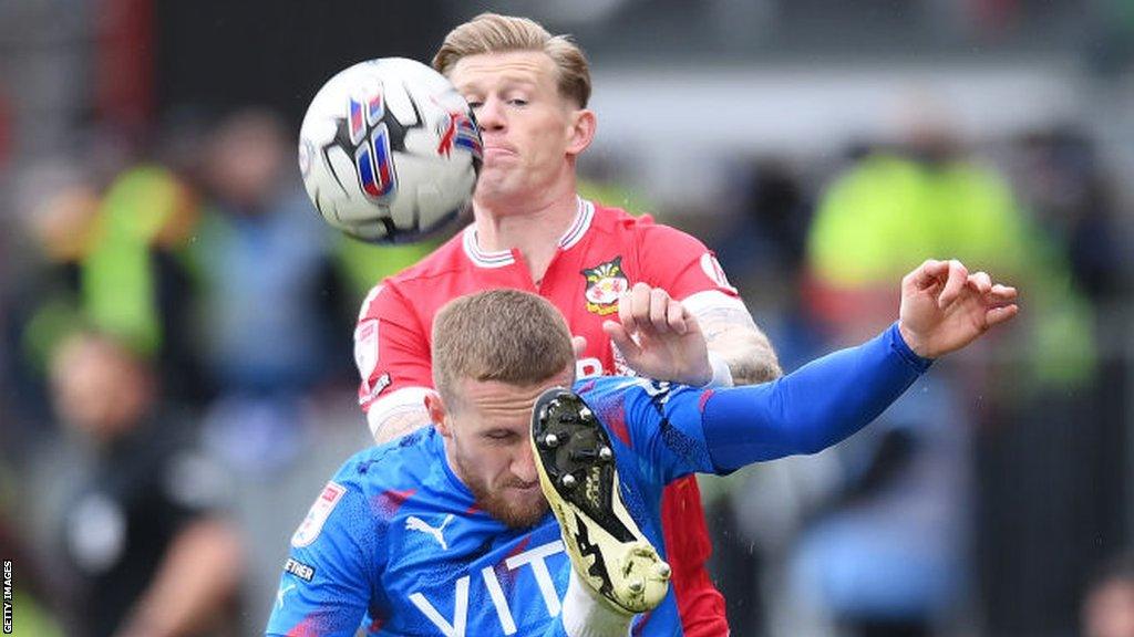 Stockport's Connor Lemonheigh-Evans clears the ball from Wrexham midfielder James McCclean