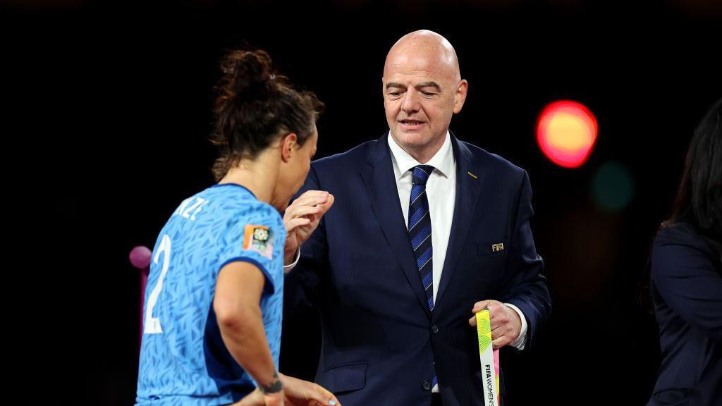 Gianni Infantino shaking Lucy Bronze's hand