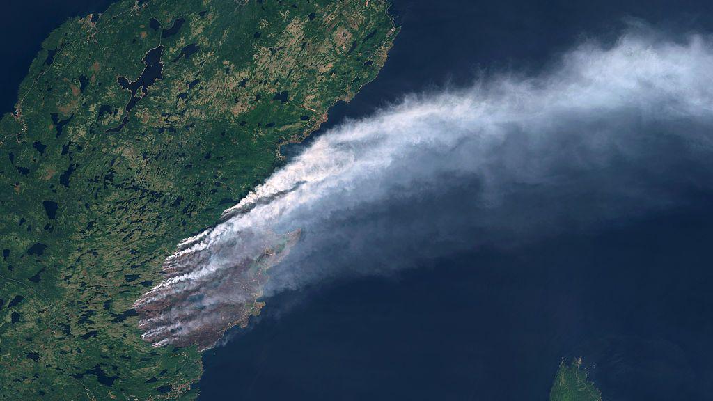 Satellite view of the Kingston Fire shows a thick smoke plume rising over Conception Bay North in Newfoundland and Labrador, Canada, where the province’s largest wildfire has triggered evacuations and air quality warnings. 