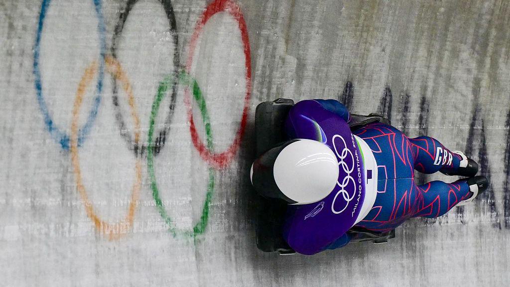 Matt Weston doing the skeleton with olympic rings in the background