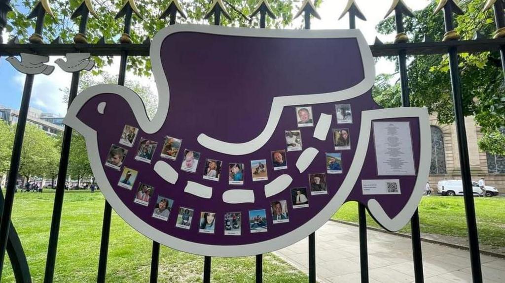 An artwork depicting a giant dove and photographs of crash victims