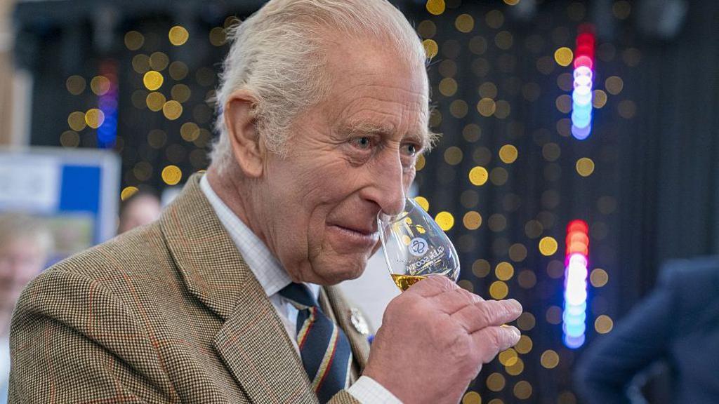 King Charles with a whisky glass