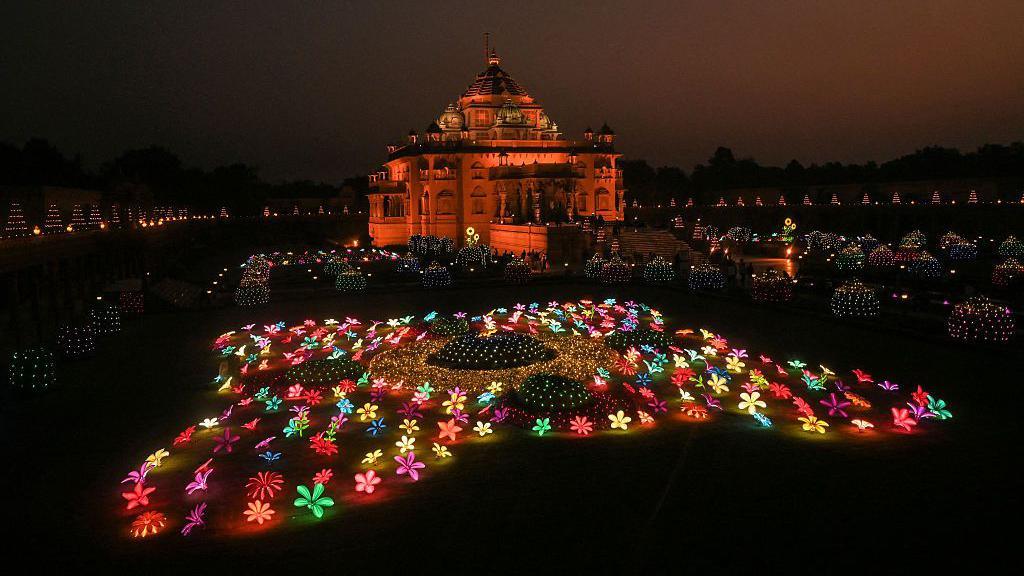 A temple with a colourful light display outside.