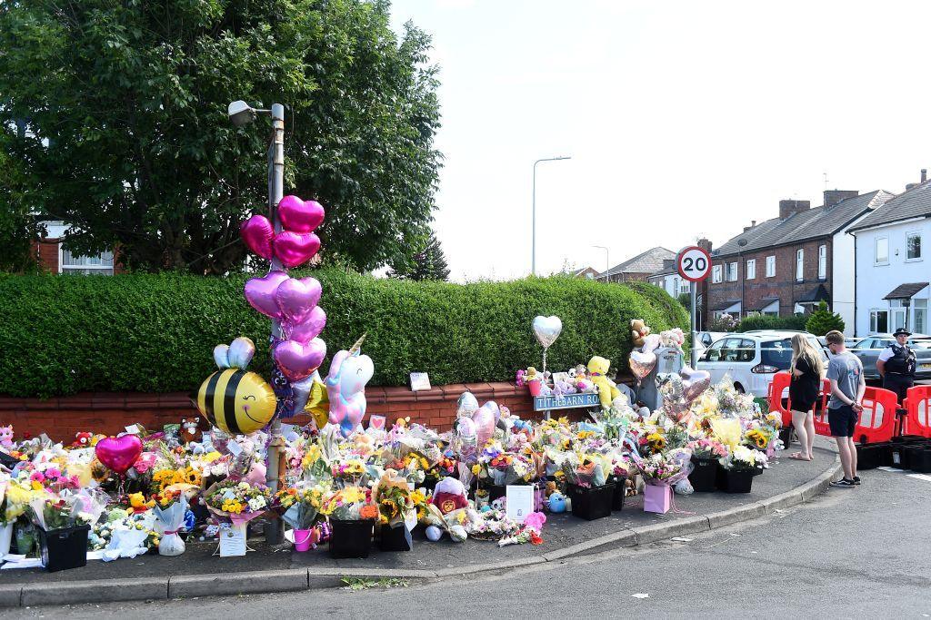 Residents look at floral tributes for the victims of a deadly knife attack in Southport