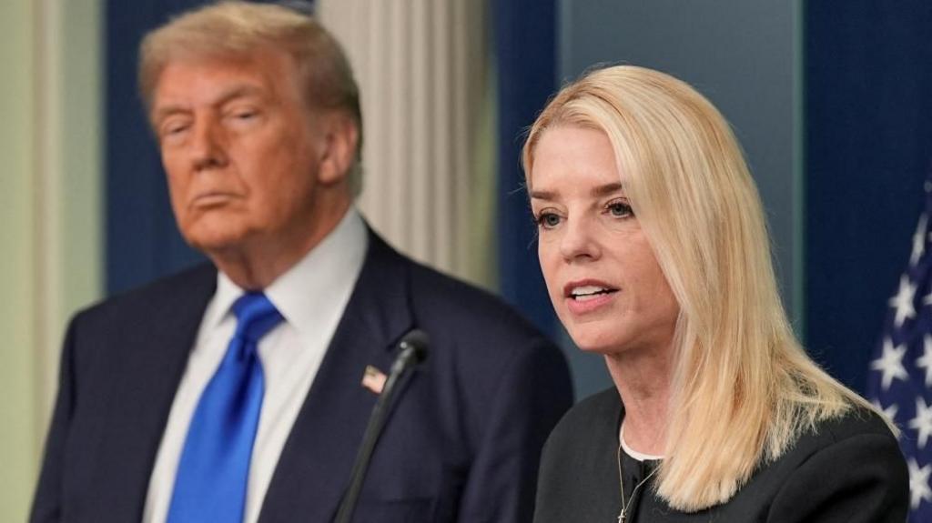 Donald Trump stands to the left of US Attorney General Pam Bondi as she speaks to the media,