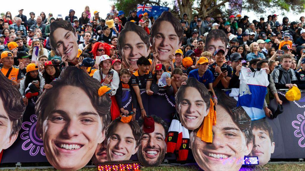 Australian fans hold up giant heads of home driver Oscar Piastri 