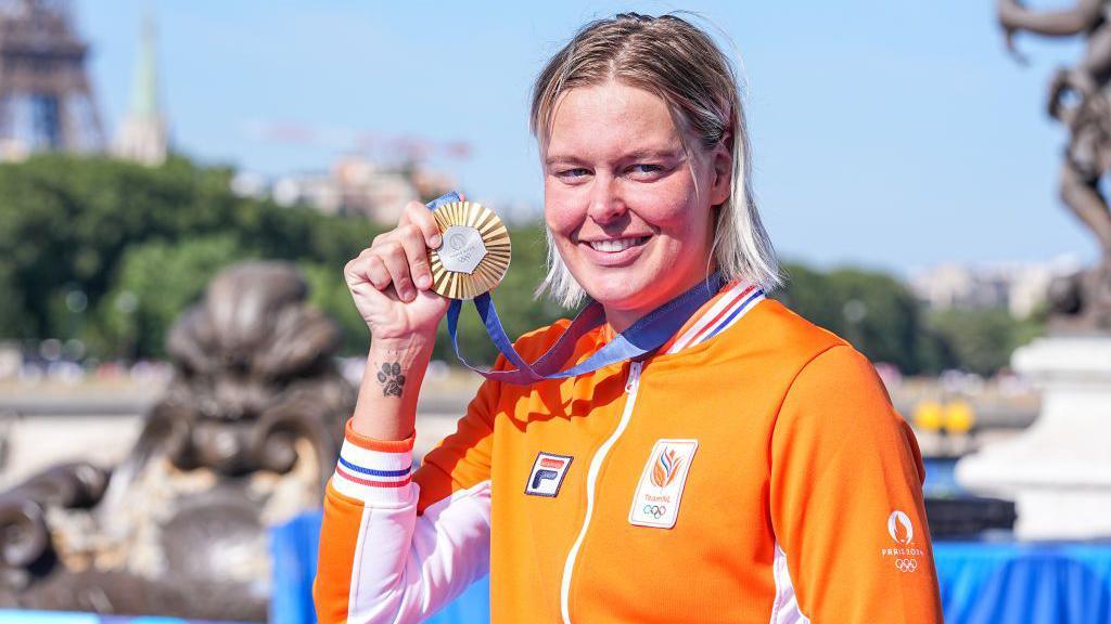 Van Rouwendaal holds gold medal and shows dog paw tattoo