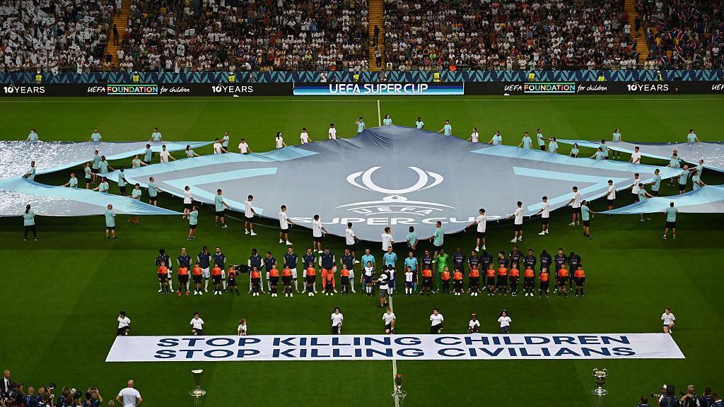 A banner saying "stop killing children, stop killing civilians' is displayed during the Super Cup final 