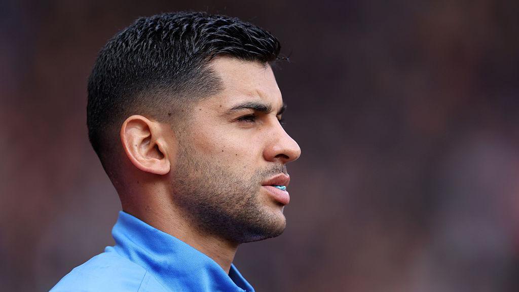 Cristian Romero looks on