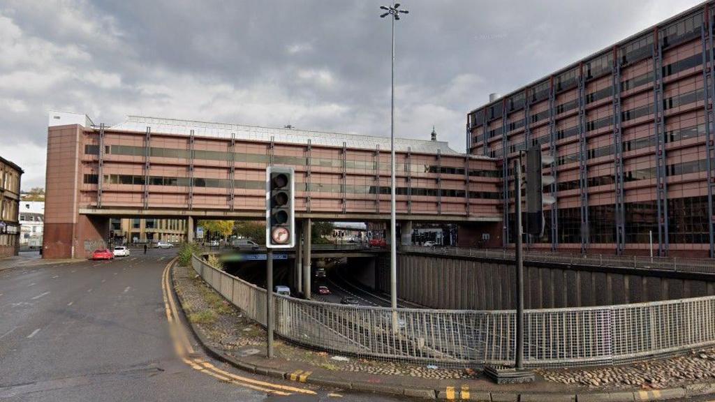 The Tay House bridge, a building on a bridge over the M8 motorway in Glasgow, can be seen in the distance. Beneath the road to Charing Cross is the M8 motorway.