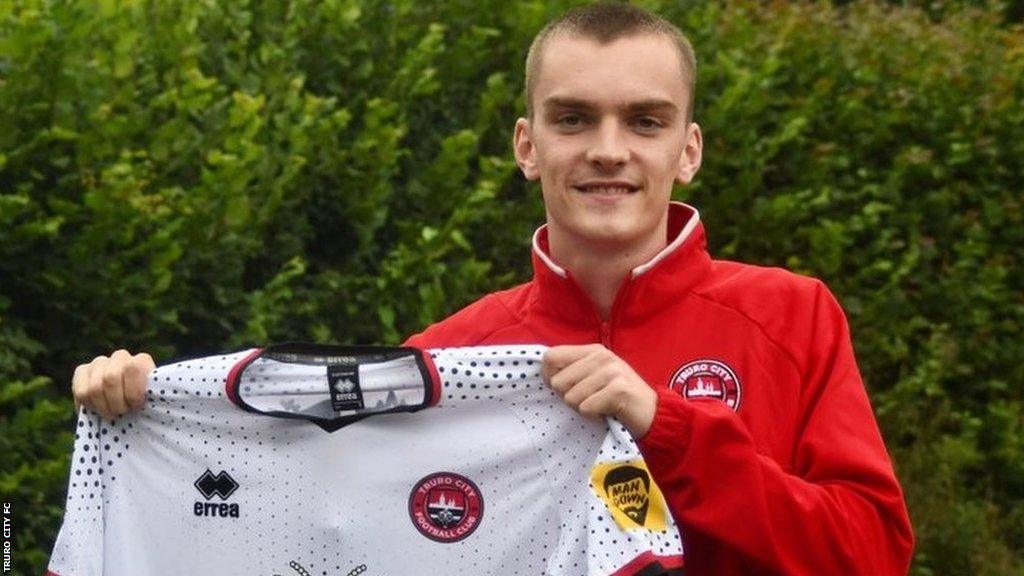 Adam Porter holds up a Truro City shirt