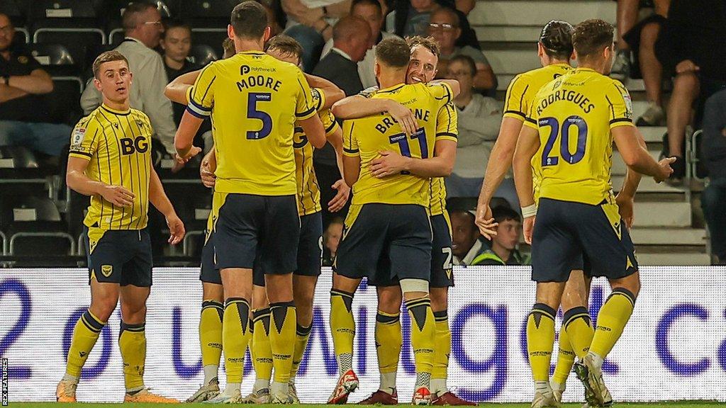 Oxford United players celebrate with goal scorer Mark Harris in their 2-1 win over Derby County at Pride Park.