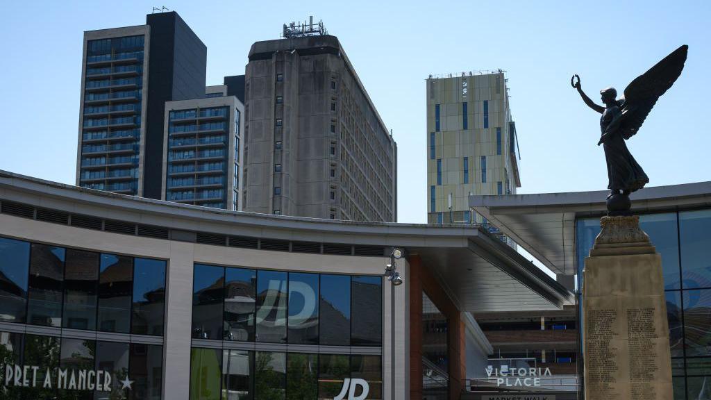 An angel on the top of the war memorial looks towards the Victoria Place retail and residential complex