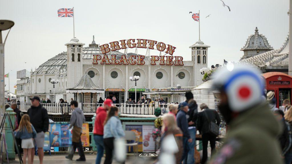 A pier with many people walking across it.