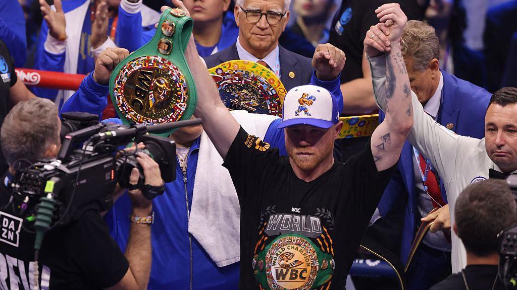 Saul Canelo Alvarez celebrates with all the belts