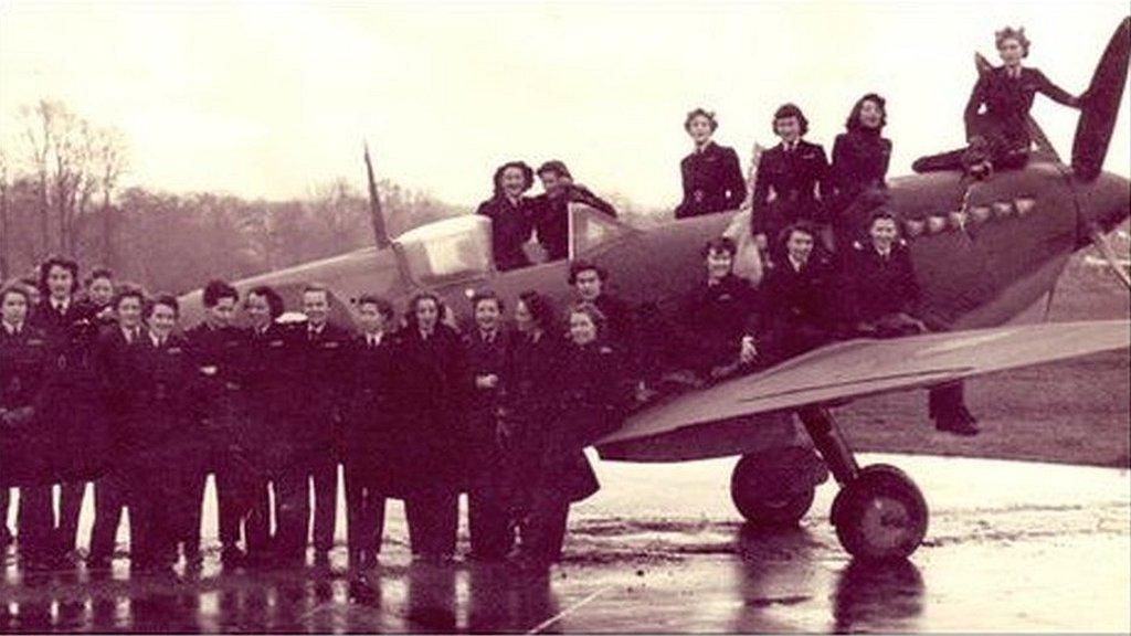 A group of women posing with a spitfire at Hamble Airfield in Southampton