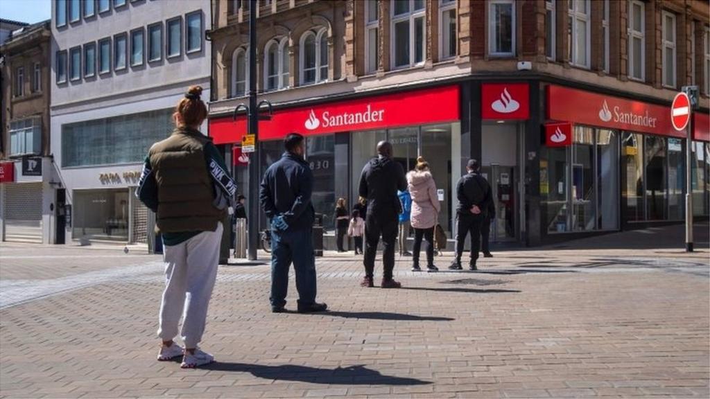 Customers socially distancing outside a Santander bank in Leeds