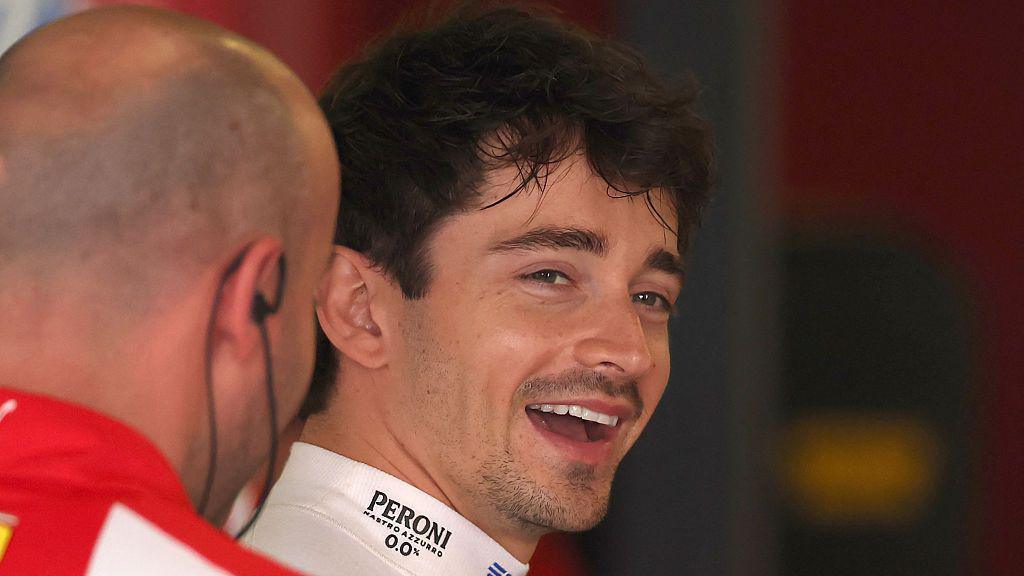 Charles Leclerc smiles while in the Ferrari garage 