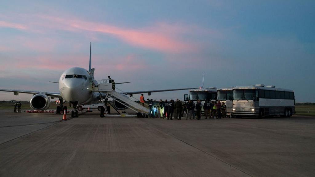 Migrants boarding a deportation flight to Venezuela in October 2023