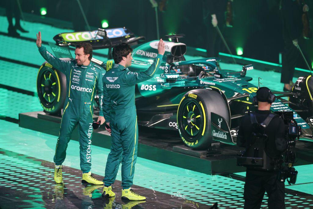 Aston Martin drivers Fernando Alonso and Lance Stroll wave to the crowd at the O2 Arena