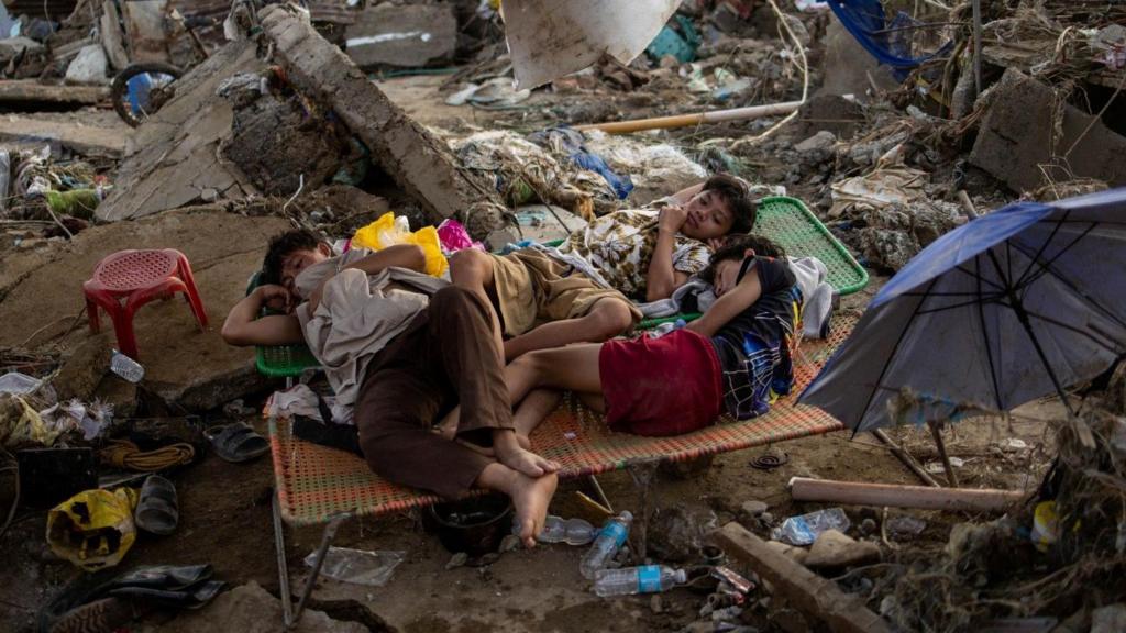 Children lie on makeshift beds amid piles of debris in Cebu, Philippines 