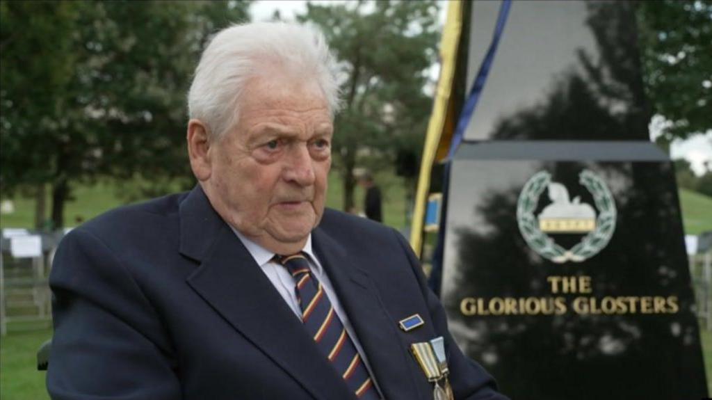 Ted Warwick sat next to the black granite memorial in a wheelchair