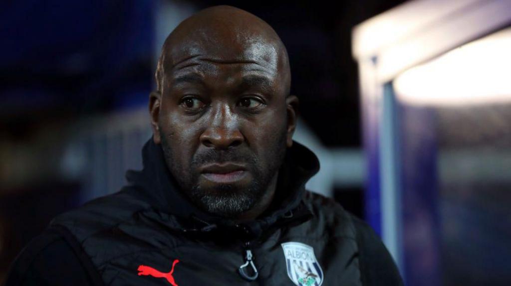 Darren Moore sits in the dugout during his spell as West Bromwich Albion head coach