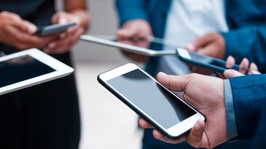 A stock photograph of people in suits holding phones