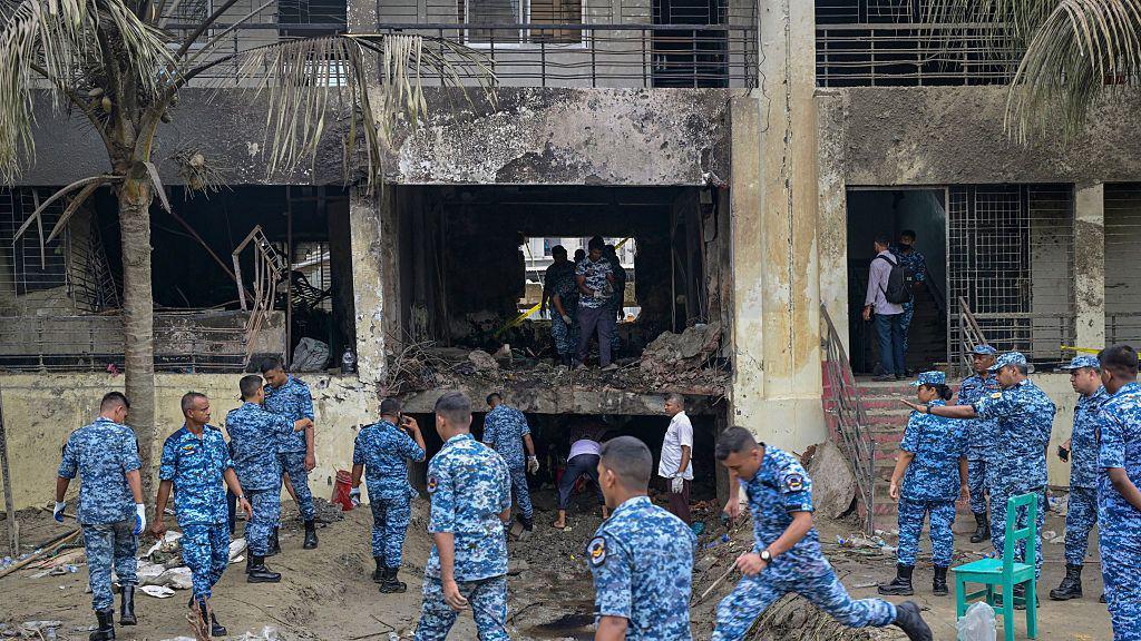 Bangladesh Air Force personnel inspect the crash site a day after a training jet crashed into a school in Dhaka on July 22, 2025