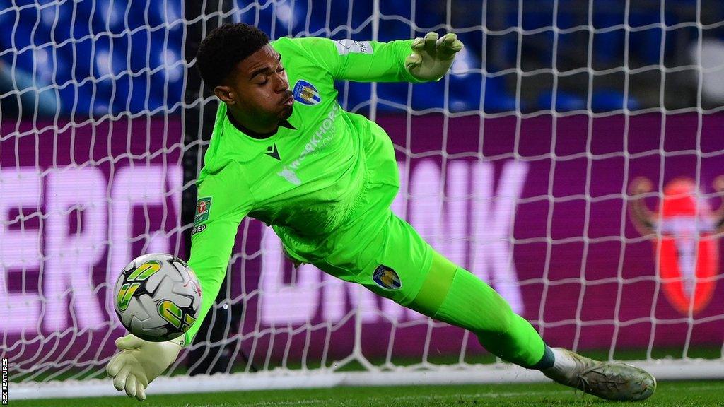 Colchester goalkeeper Owen Goodman saves a penalty kick