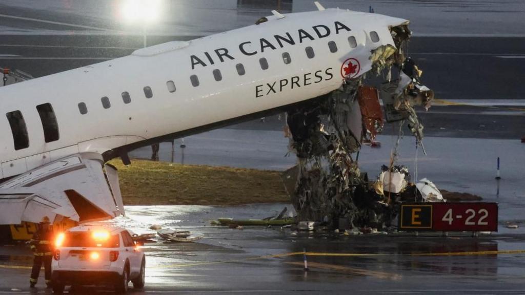 Debris hangs from a damaged Air Canada Express jet that had collided with a ground vehicle at New York's LaGuardia Airport in Queens, New York, U.S