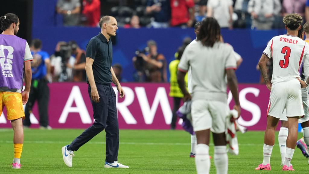 England manager walks across the pitch among his players after losing to Argentina in the World Cup semi-final