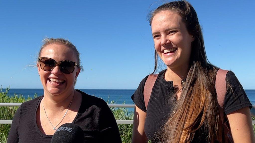 Two women smilling by the beach