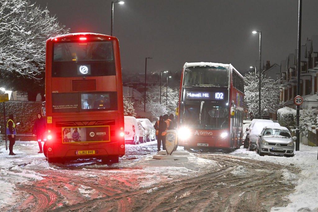 Two buses stuck in snow in Muswell Hill, London