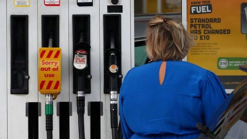 A woman fills up her car