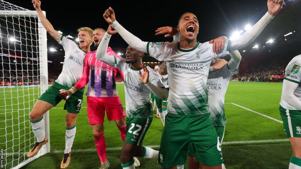 Lincoln City players celebrate following the penalty shootout after the Carabao Cup Second Round match between Sheffield United and Lincoln City at Bramall Lane