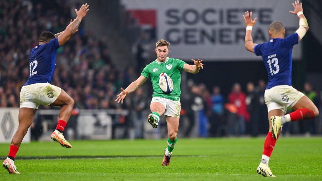 Ireland's Jack Crowley kicks the ball as French players seek to close him down